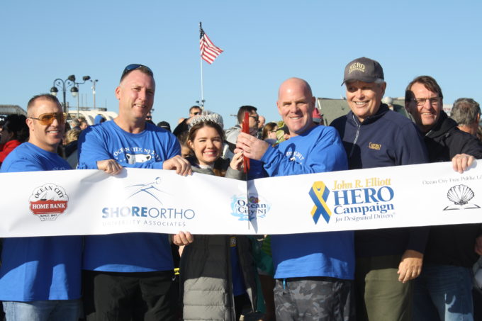 From left, Dr. Charles Krome and Dr. Tom Barrett of Shore Orthopedics; Kristina Sweeney, Miss Night in Venice; Richard Sweeney, Ironworkers Local 399; Bill Elliott, founder of the HERO Campaign; and Ocean City Mayor Jay Gillian prepare to cut a HERO Campaign banner for the start of the plunge. 
